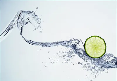 Produktbild von Wallario Fototapete Vliestapete, seidenmatte Oberfläche, einfache Verarbeitung, Größe 350 x 245 cm, Motiv Limettenscheibe in spritzigem Wasser