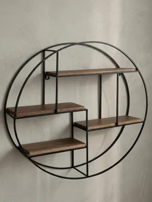Frontansicht des runden Wandregals mit 70 cm Durchmesser, das die asymmetrische Anordnung der vier Ablagen aus Mangoholz im schwarzen Metallrahmen zeigt._#sku_BARWL6.750#