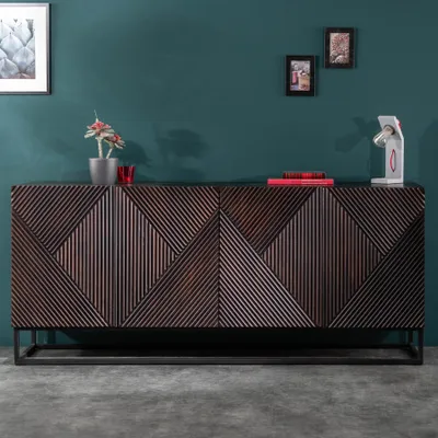 A sideboard with a geometric pattern is displayed in a room with a teal wall and gray floor. Decorative items are placed on top of the sideboard.
