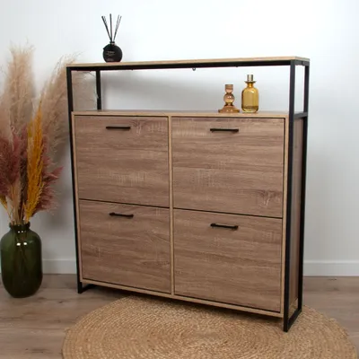A wooden shoe cabinet with black metal frame, decorated with dried flowers and decorative bottles.
