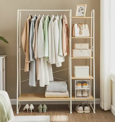 A clothing rack and shelving unit displaying clothes, bags, and shoes in a room setting.
