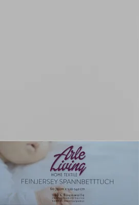 A close-up of a baby's face and a product label for a baby jersey fitted sheet.