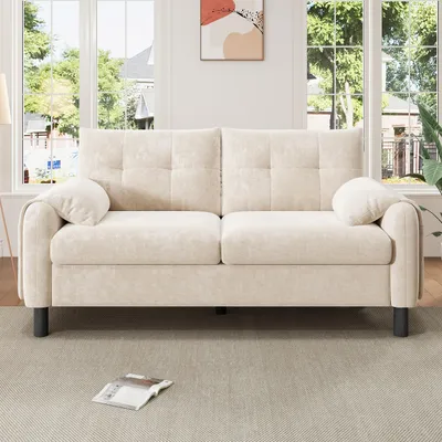 A beige sofa is shown in a well-lit room with large windows in the background.