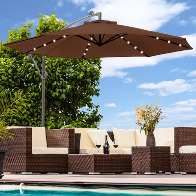 A patio set with a large umbrella, chairs, and a table next to a pool.