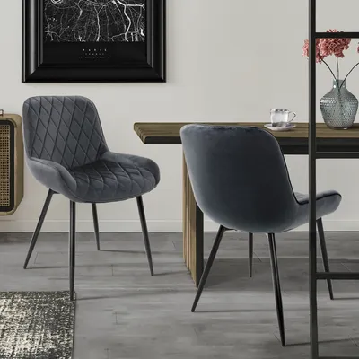 Two dining chairs are placed around a wooden dining table in a modern dining room setting.