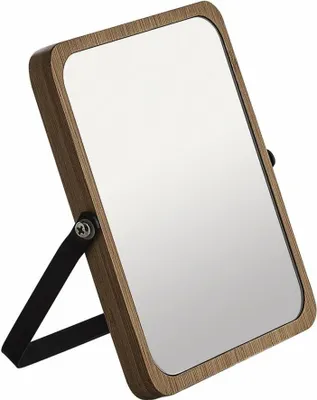 A close-up, angled view of a freestanding cosmetic mirror with a wooden frame and a black stand.