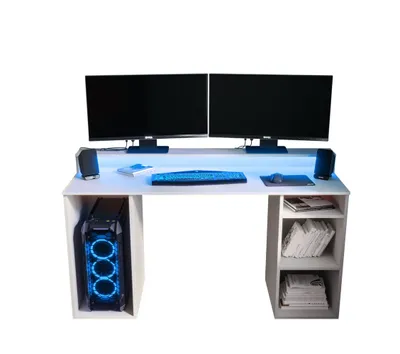 A white computer desk with two monitors, a keyboard, mouse, speakers, and a computer tower. The desk has built-in shelving on the right side.