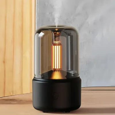 Aroma diffuser with a light bulb inside, emitting mist.