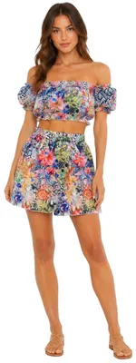 Damenmodel trägt ein schulterfreies Crop Top und eine kurzer Wickelrock im farbenfrohen Tropical-Print auf weißem Hintergrund. Das Model trägt Kleidungsgröße 38.