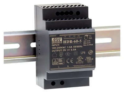 A black power supply unit is mounted on a silver DIN rail.