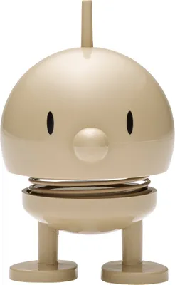 A product shot of a small, beige, spring-loaded toy figure.
