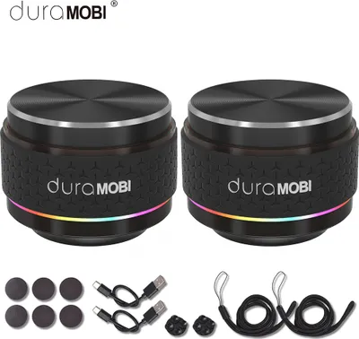 Two black cylindrical speakers with silver tops and LED lights at the base, along with accessories like charging cables and small circular pads.