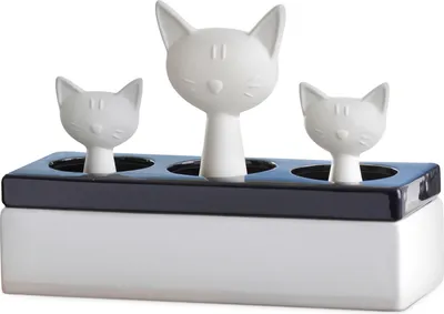 A white ceramic humidifier shaped like a family of cats sitting in a black tray.