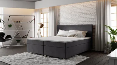 A bedroom scene with a bed, shelving unit, and chair.