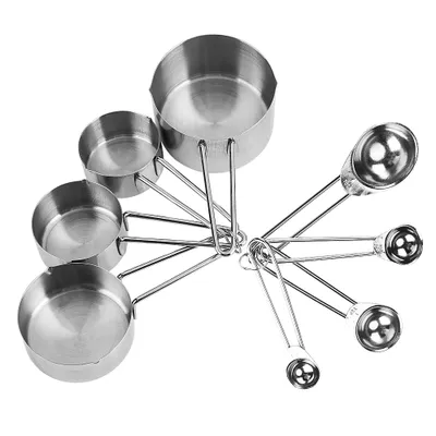 A set of stainless steel measuring cups and spoons arranged in a fan shape.