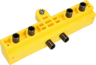 A yellow jig with black metal bushings for drilling holes.