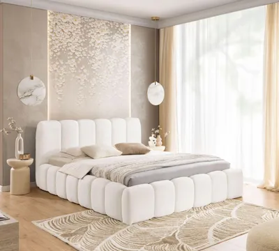 A white upholstered bed with a textured headboard and decorative wall art in a bedroom setting.