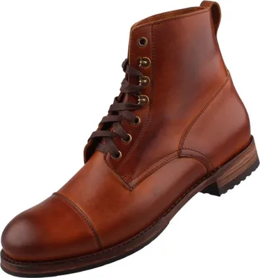 Auf dem Bild ist ein brauner Stiefel zu sehen der aus Leder gefertigt ist und eine robuste Sohle hat. Der Stiefel wird von der linken Seite präsentiert.