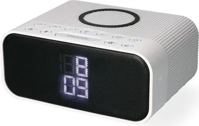 A white alarm clock with a digital display and speaker grille.