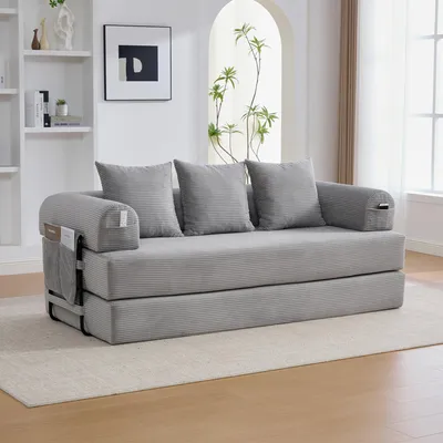A gray sofa bed with three pillows is shown in a living room setting.