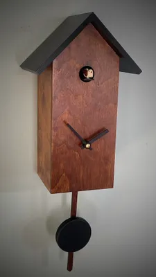 A modern cuckoo clock made in the Black Forest, hanging on a wall.