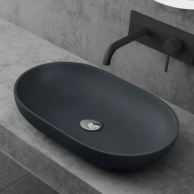 A modern bathroom sink with a matte anthracite finish, mounted on a concrete countertop.