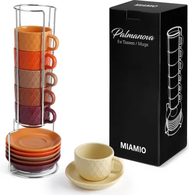 A set of espresso cups and saucers stacked on a rack, with a single cup and saucer in the foreground, and a product box in the background.