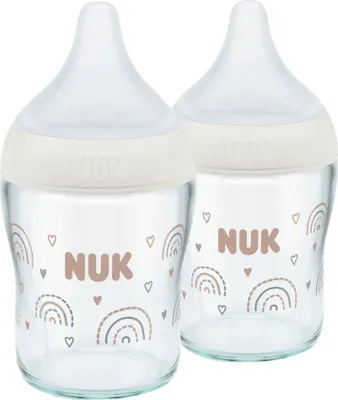 Two glass baby bottles with white nipples and beige collars, decorated with rainbow and heart patterns.