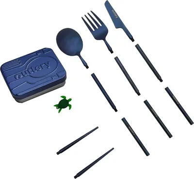 A set of disassembled cutlery and a small turtle figurine on a white background.