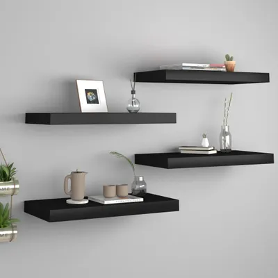 Four black floating shelves are mounted on a light gray wall, each displaying various decorative items and books.