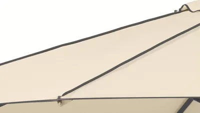 A close-up view of a cream-colored umbrella fabric with black trim.