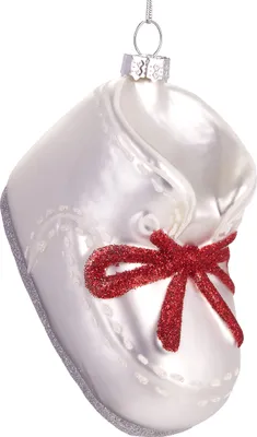 A white glass baby shoe ornament with a red glitter bow.