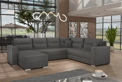 A spacious living room with a large sectional sofa, large windows, and modern decor.