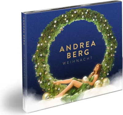 A product cover for a Christmas album by Andrea Berg, featuring a woman in a green dress lying on snow next to a Christmas wreath.