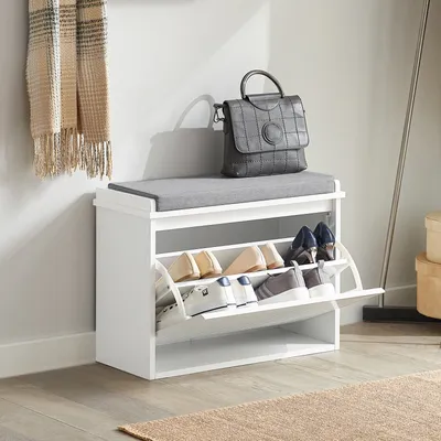 A shoe cabinet with a cushioned seat on top, placed in a hallway or entryway.