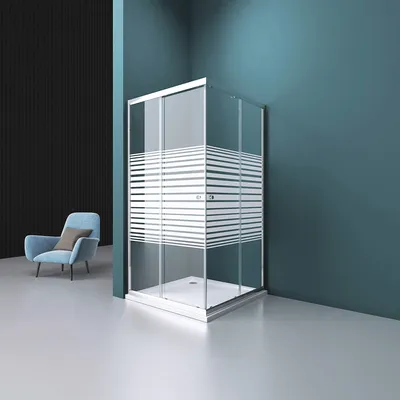 A modern shower enclosure with a striped frosted glass design, placed in a minimalist bathroom setting with a blue wall and a light blue armchair.