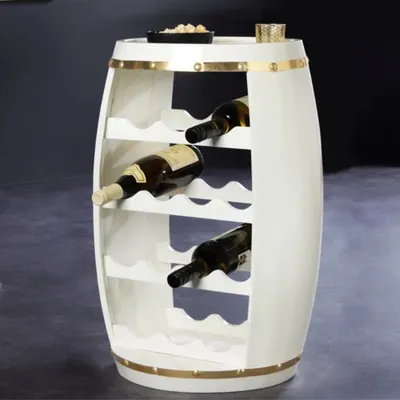 A white barrel-shaped wine rack with gold accents, holding several wine bottles.