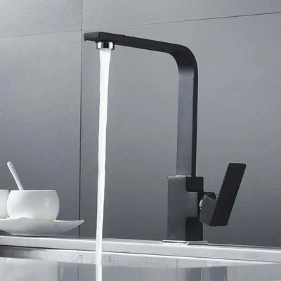 A black kitchen faucet with water running into a sink.