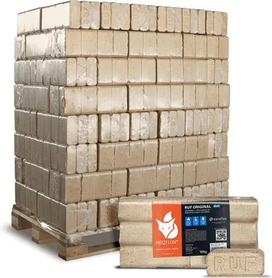 A pallet of compressed wood briquettes for heating, with a smaller package of briquettes in the foreground.
