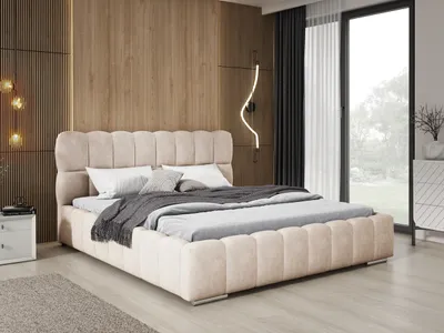 A bedroom scene featuring a beige upholstered bed.