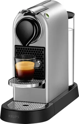 A silver Nespresso coffee machine with a cup of espresso.