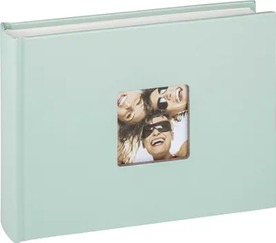A mint green photo album with a cutout window on the cover displaying a photo of three smiling young women.