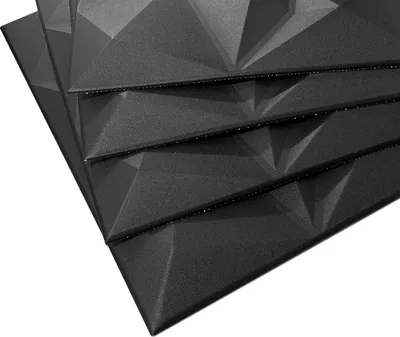 A stack of black 3D wall panels with a geometric pattern, shown from a diagonal angle against a white background.