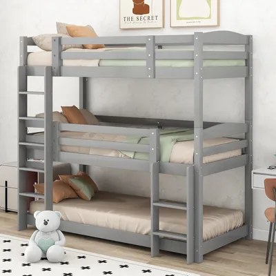 A gray triple bunk bed with mattresses and pillows in a room.