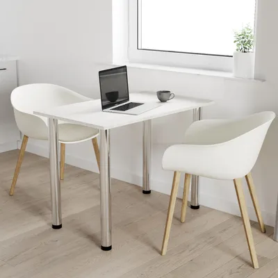 A white table with two chairs in a bright room with a window.