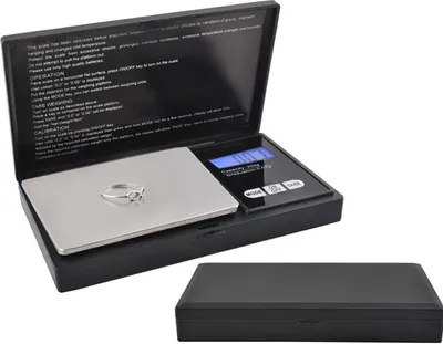 A digital scale with a lid open showing a ring on the weighing platform, and the lid closed below it.