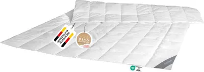 A white down comforter is laid out on a white surface.