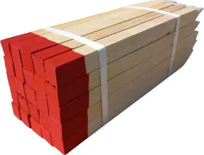 A bundle of wooden stakes with red painted tips, tied together with white bands.
