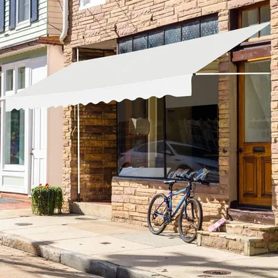 A white awning is installed over a storefront window, with a bicycle parked on the sidewalk in front of it.