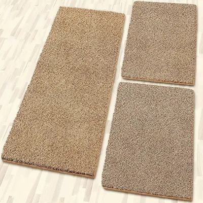 Three beige rugs of different sizes are arranged on a light-colored wooden floor.